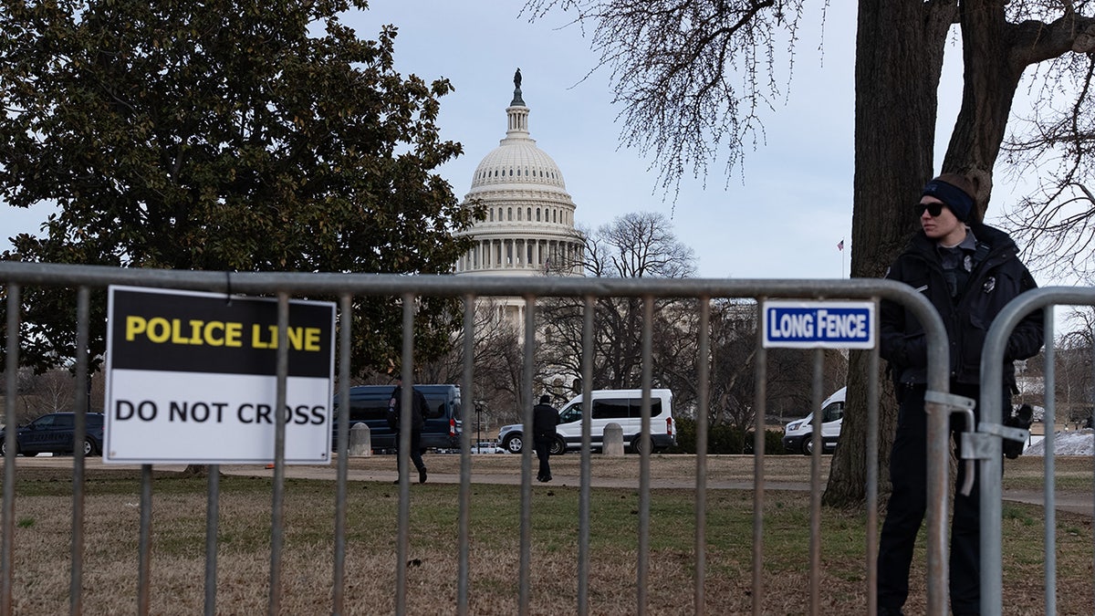 Members of the US Capitol police stand near security fencing