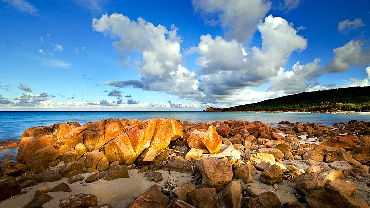 rocas en la costa con agua azul y cielo