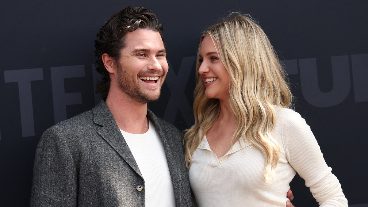 Chase Stokes and Kelsea Ballerini standing together at the Netflix Tudum live event.