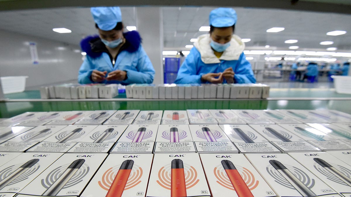 Workers are packaging e-cigarettes.