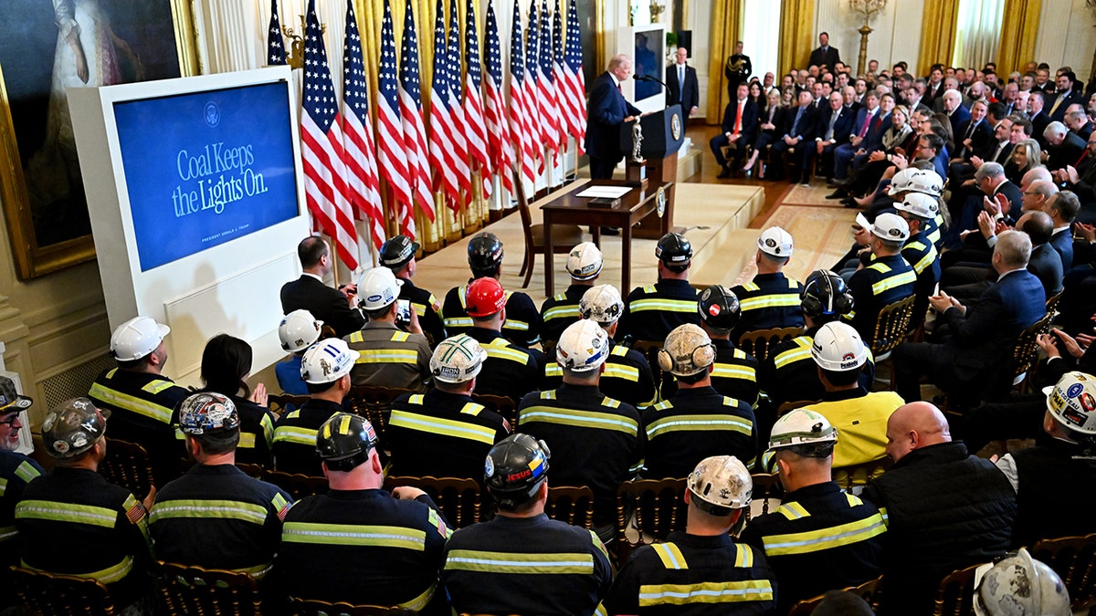 President Trump speaks at coal executive order event while coal workers look on