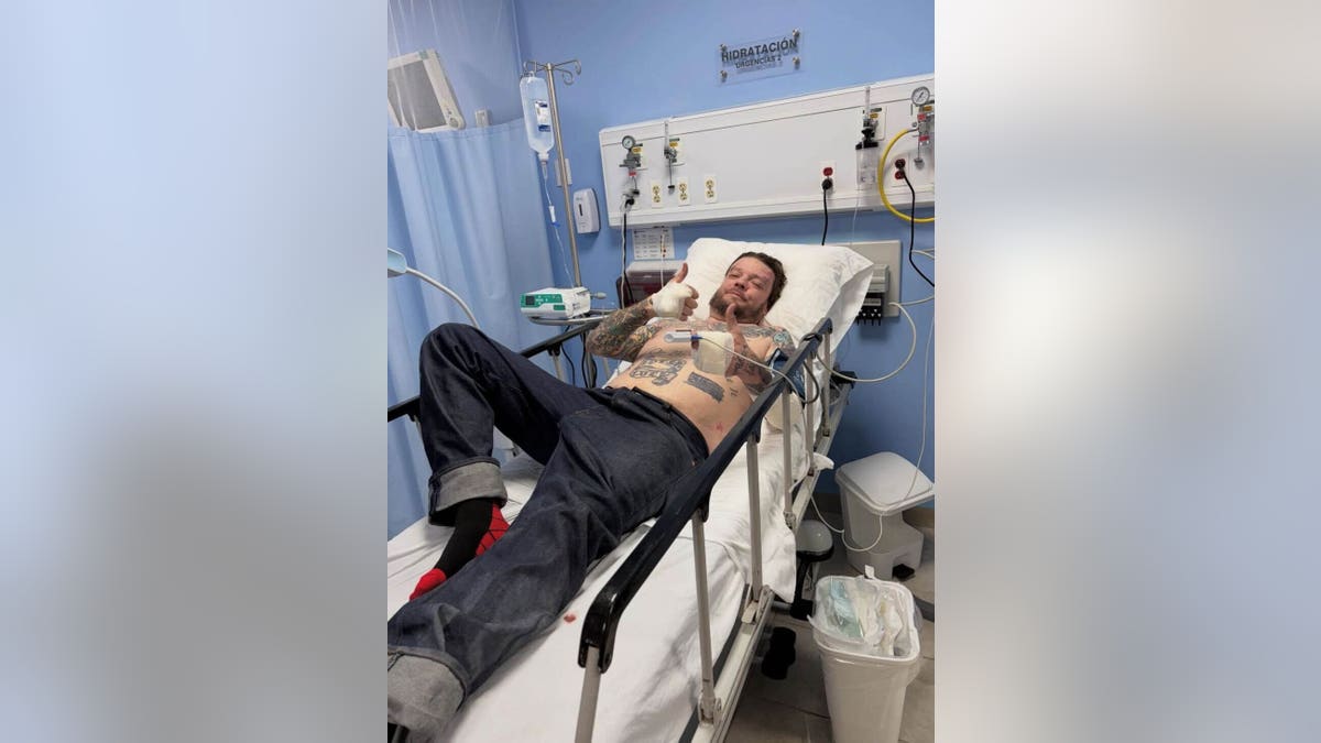 Corey Harrison lying on a hospital bed 