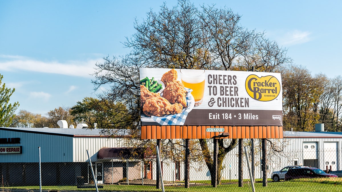 A Cracker Barrel billboard reads "Cheers to Beer & Chicken."