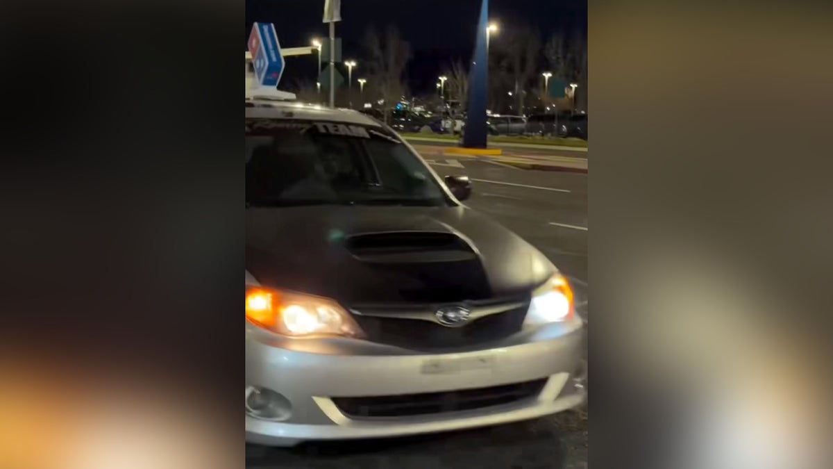 Domino's delivery driver driving up to Rogue Valley International–Medford Airport in evening.