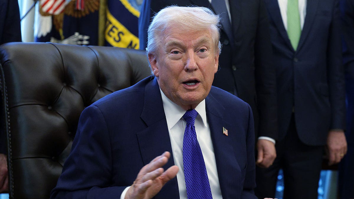 O presidente Donald Trump está sentado no Salão Oval. 