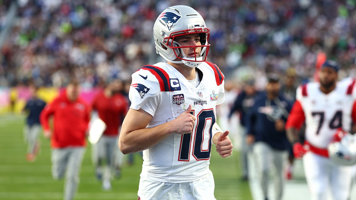 Drake Maye jogs off the football field