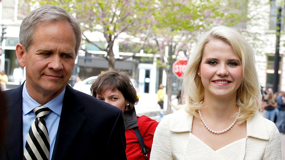 Elizabeth Smart and her father Ed Smart walk side by side away from a federal courthouse