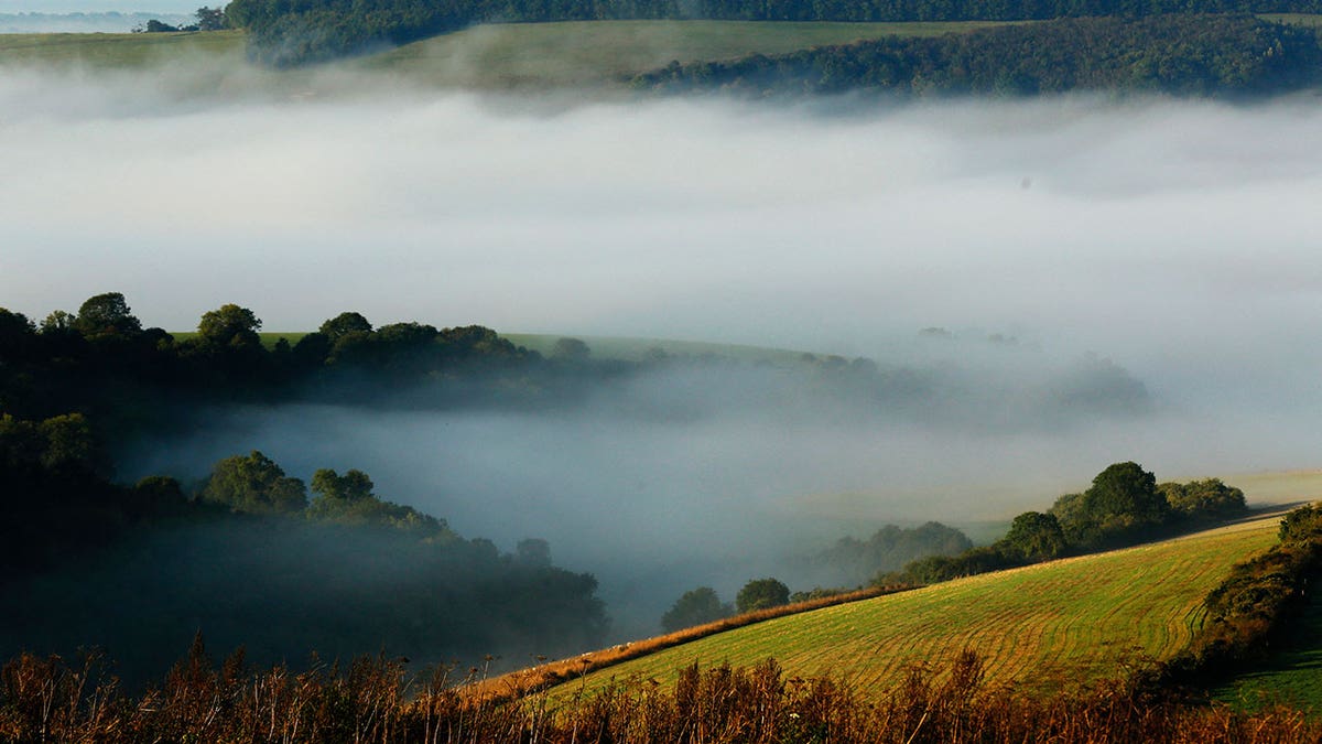 Autumn mists hang over villages and the countryside in the South Downs National Park near Amberley in Southern England