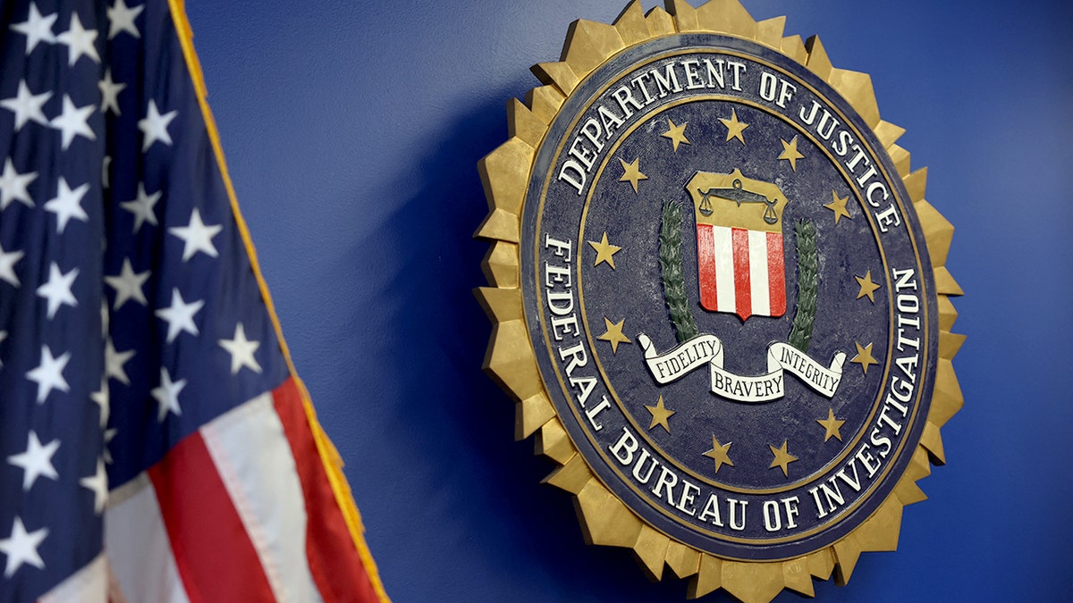 Logotipo do FBI ao lado da bandeira americana