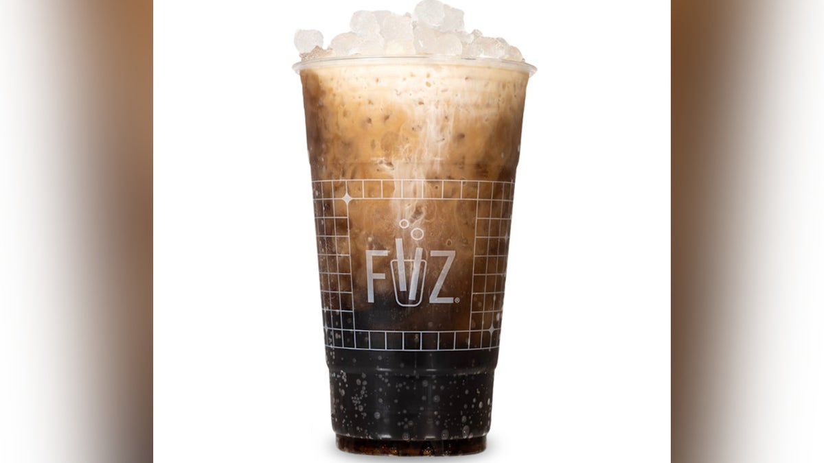 Dirty cola seen with ice and creamer.