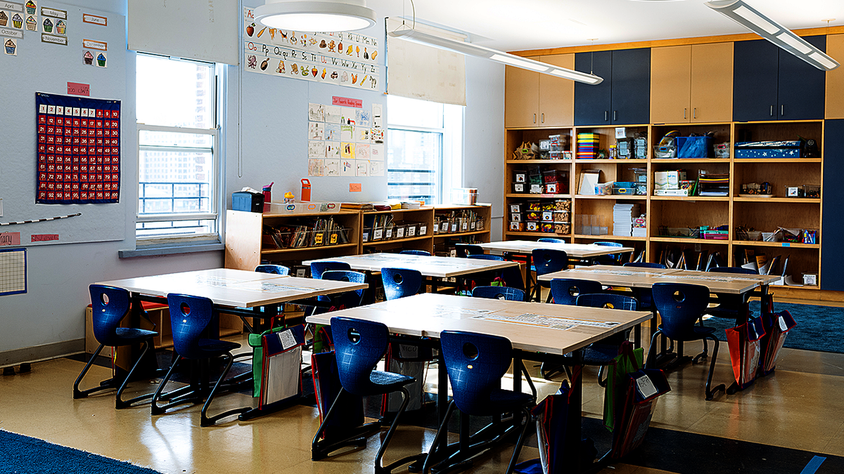 A first-grade classroom with empty desks and chairs in an elementary school.