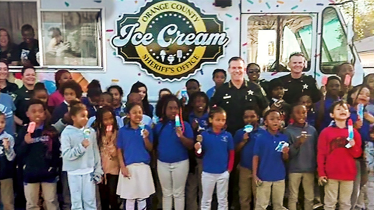 Children and officers standing outside ice cream truck