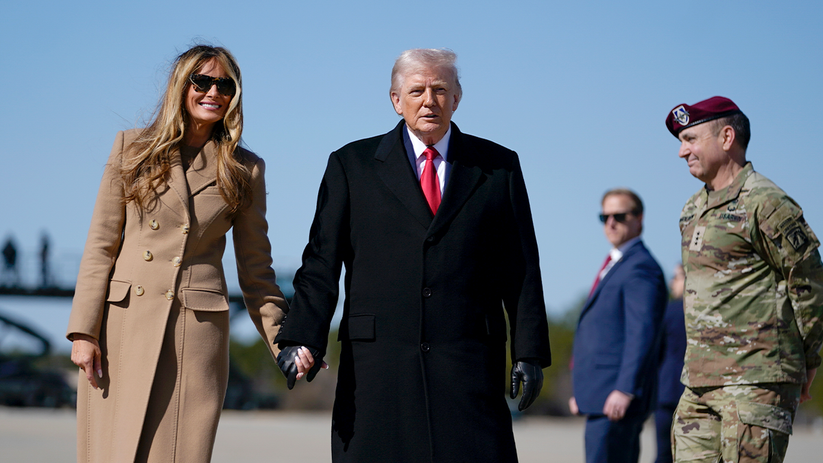 O presidente Trump e a primeira-dama Melania Trump caminham pela pista 
