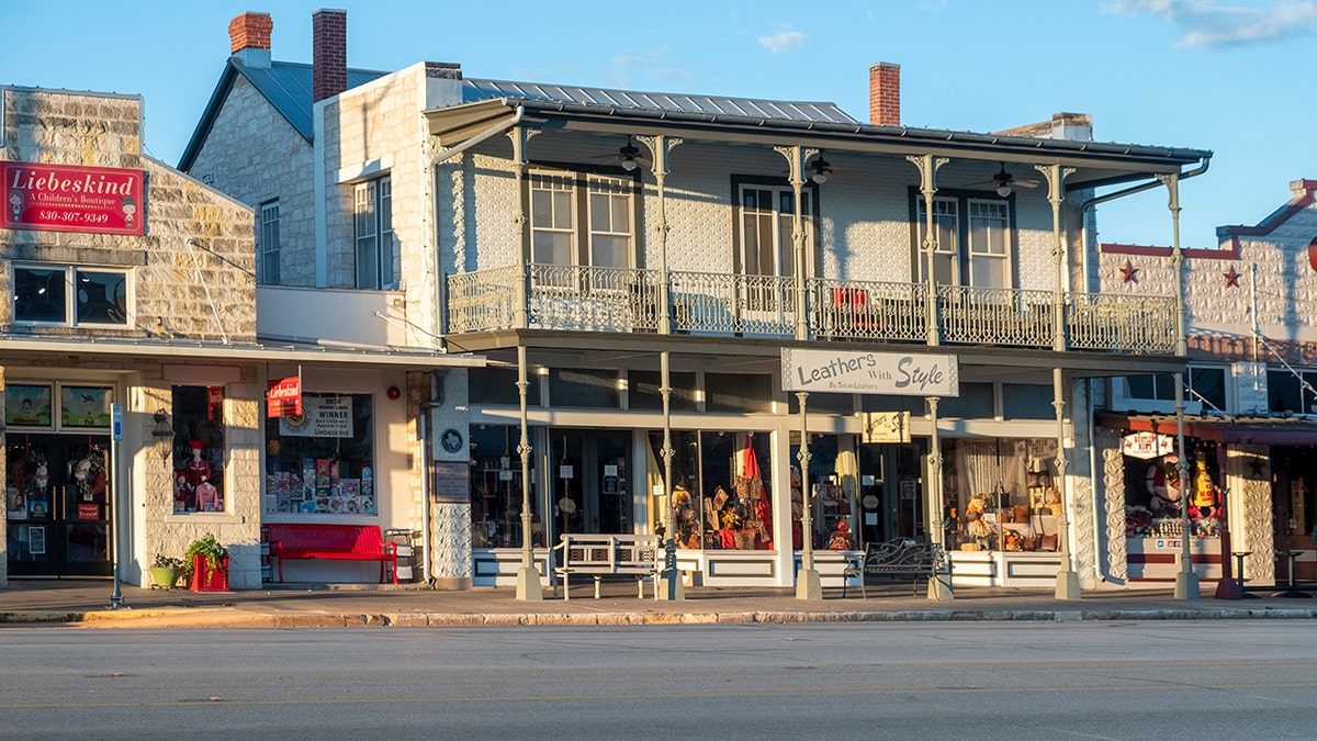 Historic downtown storefronts with stone buildings and second-story balconies.