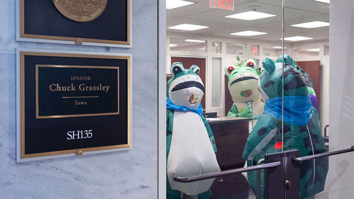 போர்ட்லேண்ட் ஃபிராக் பிரிகேட்டின் உறுப்பினர்கள், பிப்ரவரி 24, 2026 செவ்வாய் அன்று ஹார்ட் செனட் அலுவலகக் கட்டிடத்தில் உள்ள செனட்டர் சக் கிராஸ்லியின் அலுவலகத்திற்கு வருகை தந்தனர். மாலை நேர ஸ்டேட் ஆஃப் யூனியன் உரைக்கு முன்னதாக தவளைகள் அமெரிக்க அரசியலமைப்பின் நகல்களை காங்கிரஸ் உறுப்பினர்களுக்கு அளித்துக்கொண்டிருந்தன.