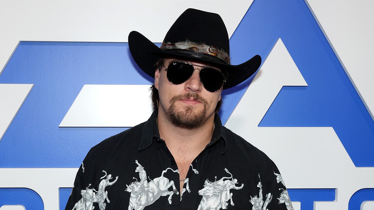 Gavin Adcock walks the blue carpet before a live performance at the Madden Bowl event during Super Bowl LX in San Francisco.