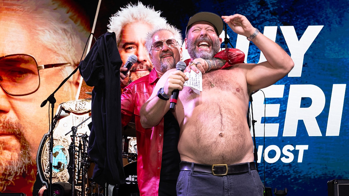 Guy Fieri e Bert Kreischer sem camisa se abraçam no 2026 South Beach Wine & Food Festival.