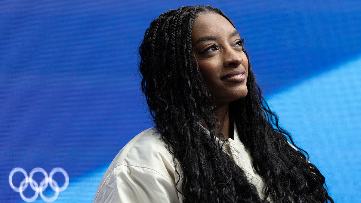 Simone Biles watches figure skating at the Winter Olympics
