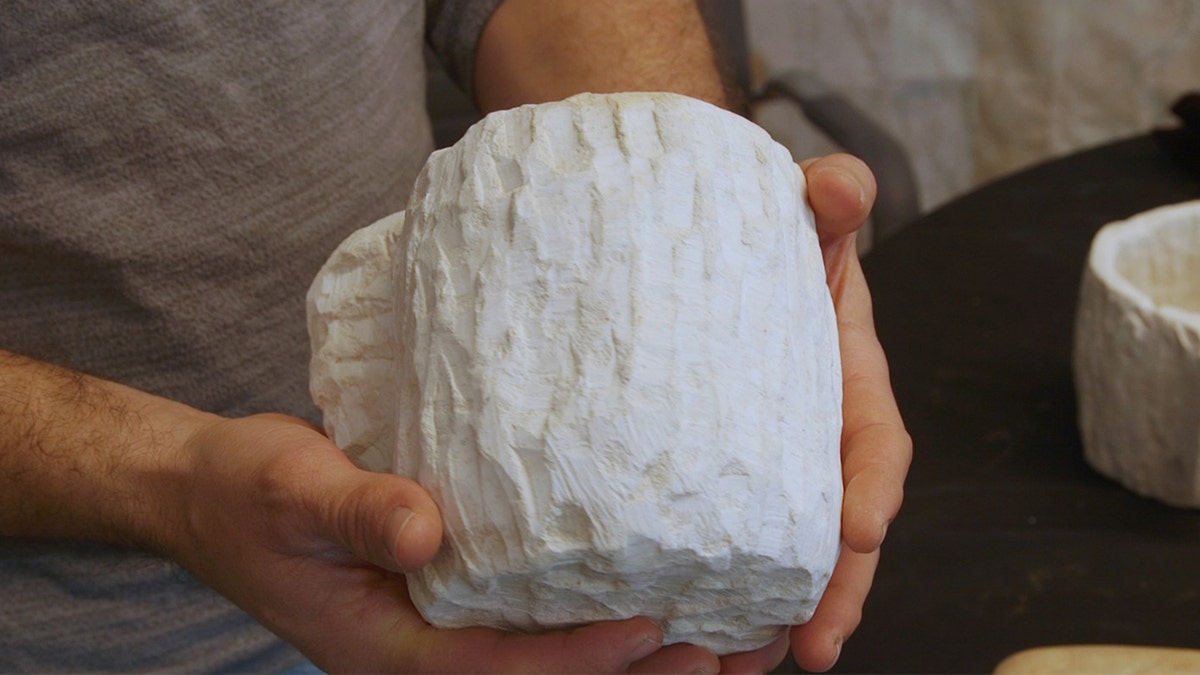 Man holding stone vessel