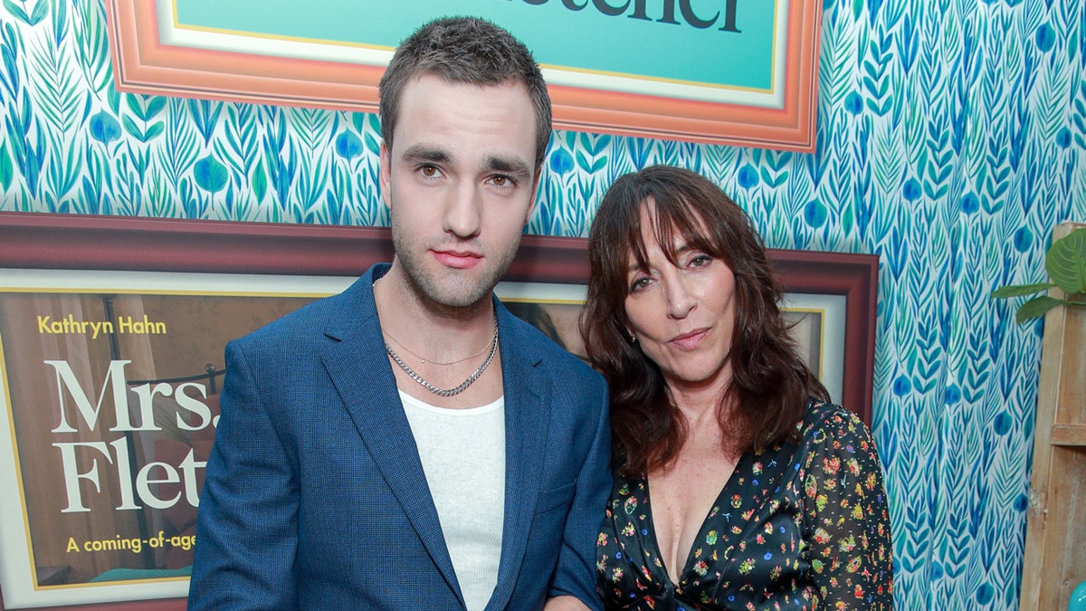 Jackson White and Katey Sagal posing together on a red carpet in front of a promotional backdrop.