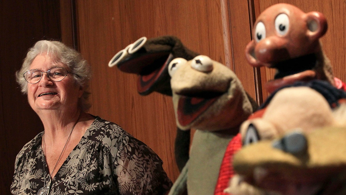 Jane Henson smiling with Muppets.