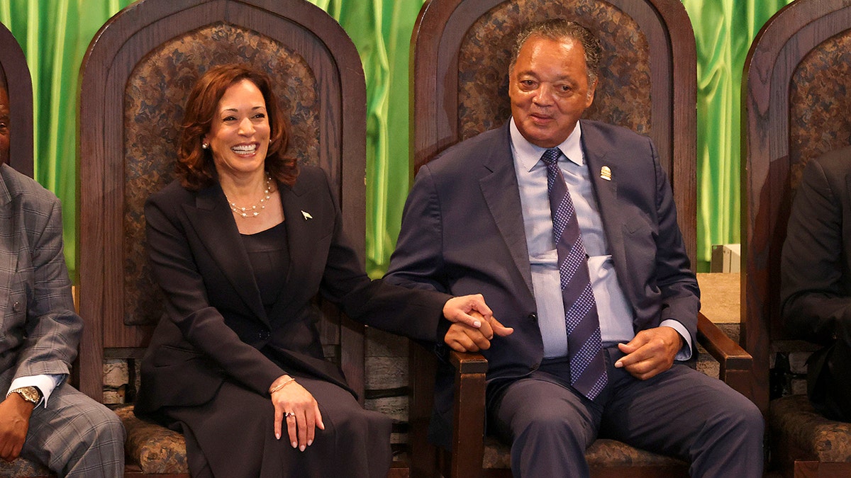 A vice-presidente Kamala Harris segura a mão do reverendo Jesse Jackson em 2023