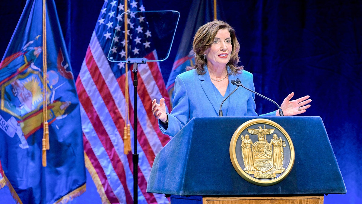Kathy Hochul staat op een podium en spreekt een publiek toe in een theater.