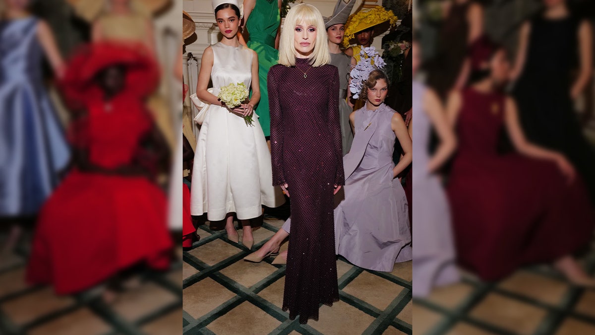 Kelly Osbourne poses in a purple gown