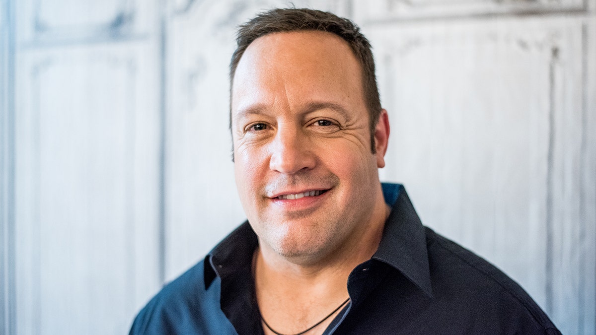 Kevin James wearing a navy button down at a premiere.
