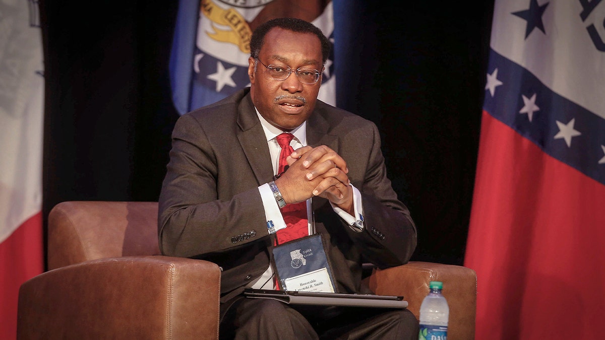 A judge sits at the podium during a legal conference.