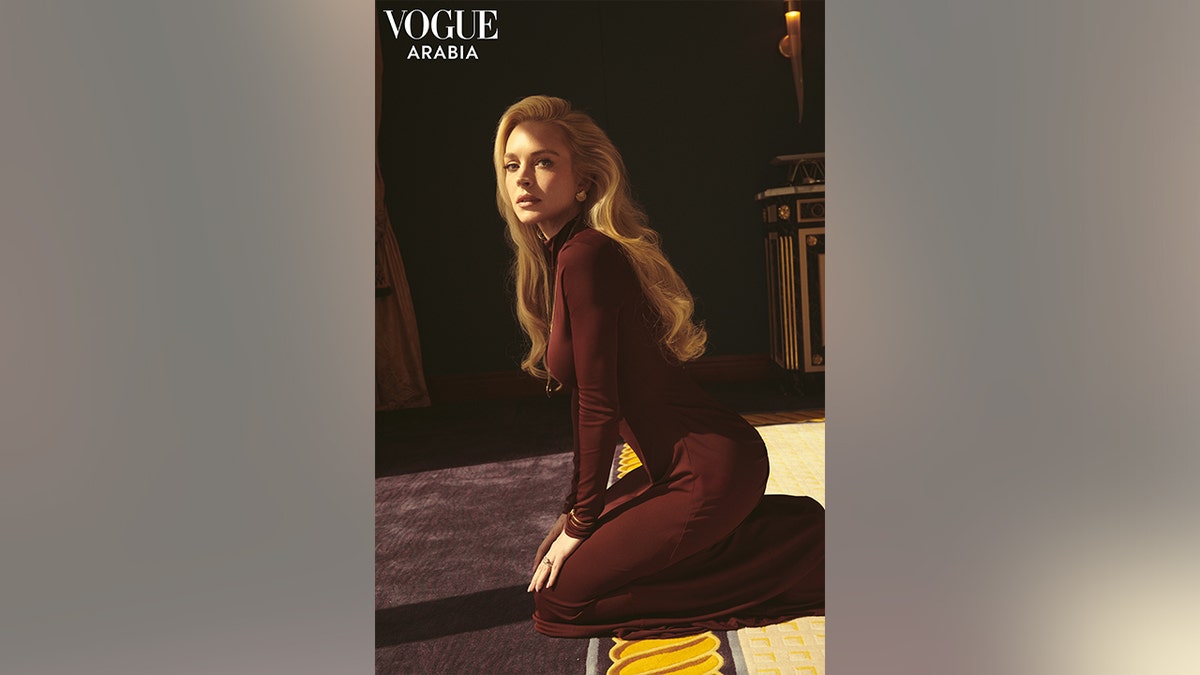 Lindsay Lohan in a brown dress posing for Vogue Arabia.
