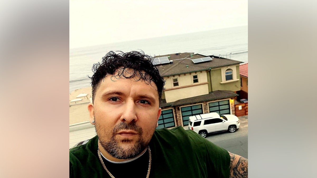 A photo of Luke Daley in front of what appears to be the beach