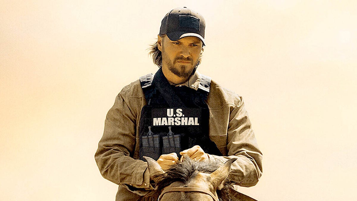 Luke Grimes sits on a horse in Marshals