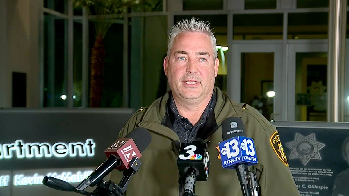 A police officer standing at a microphone during a press conference