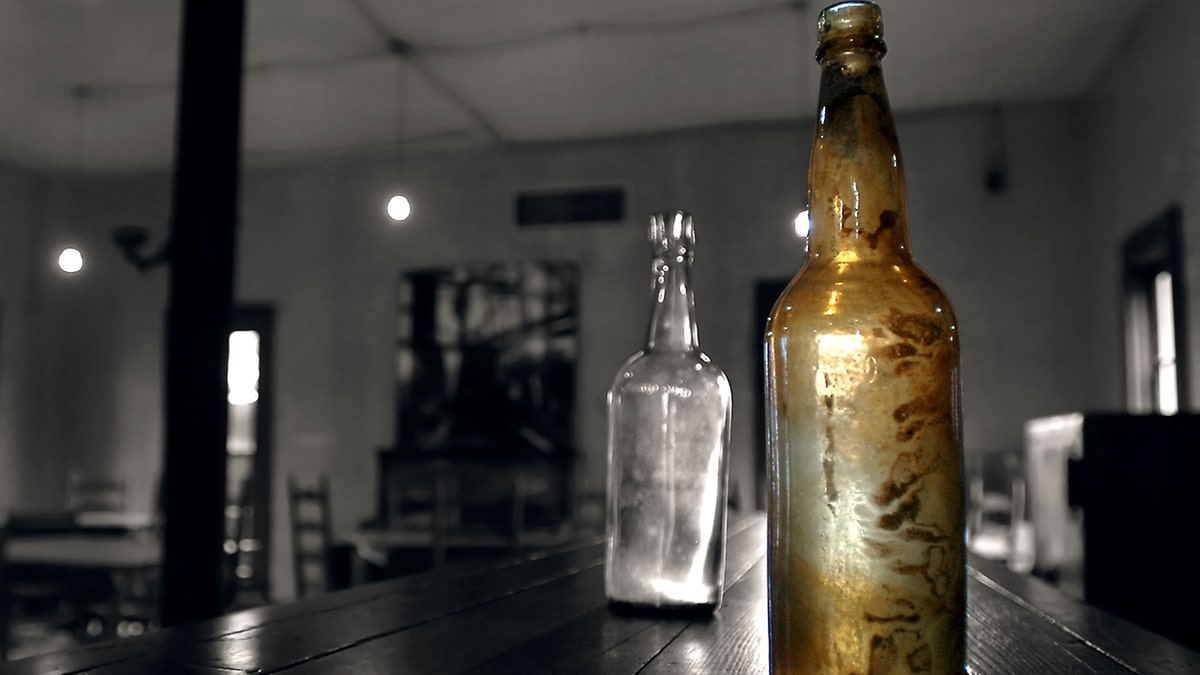 Two old bottles on bar at antique bar in Beaumont, Texas.