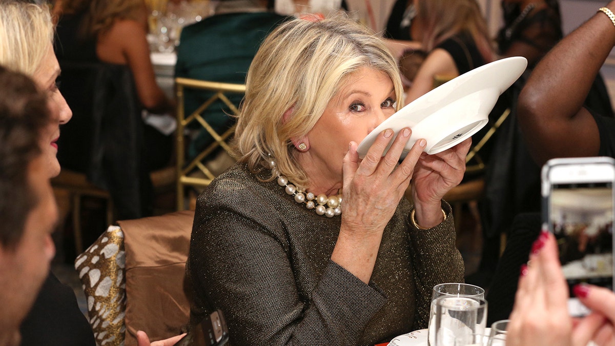 Martha Stewart holding a white bowl up to her mouth at Dinner with Ghetto Gastro hosted by Martha Stewart part of the Bank of America Dinner series curated by Chefs Club at The Pierre Hotel on October 14, 2016 in New York City.