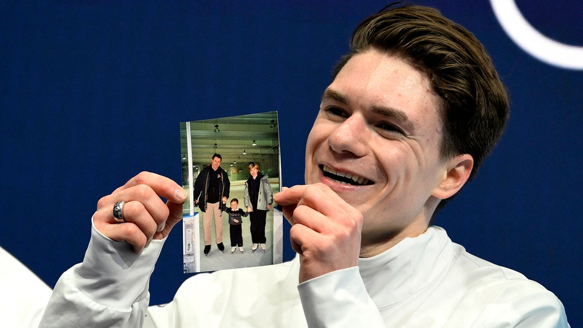 Maxim Naumov holds up picture of parents