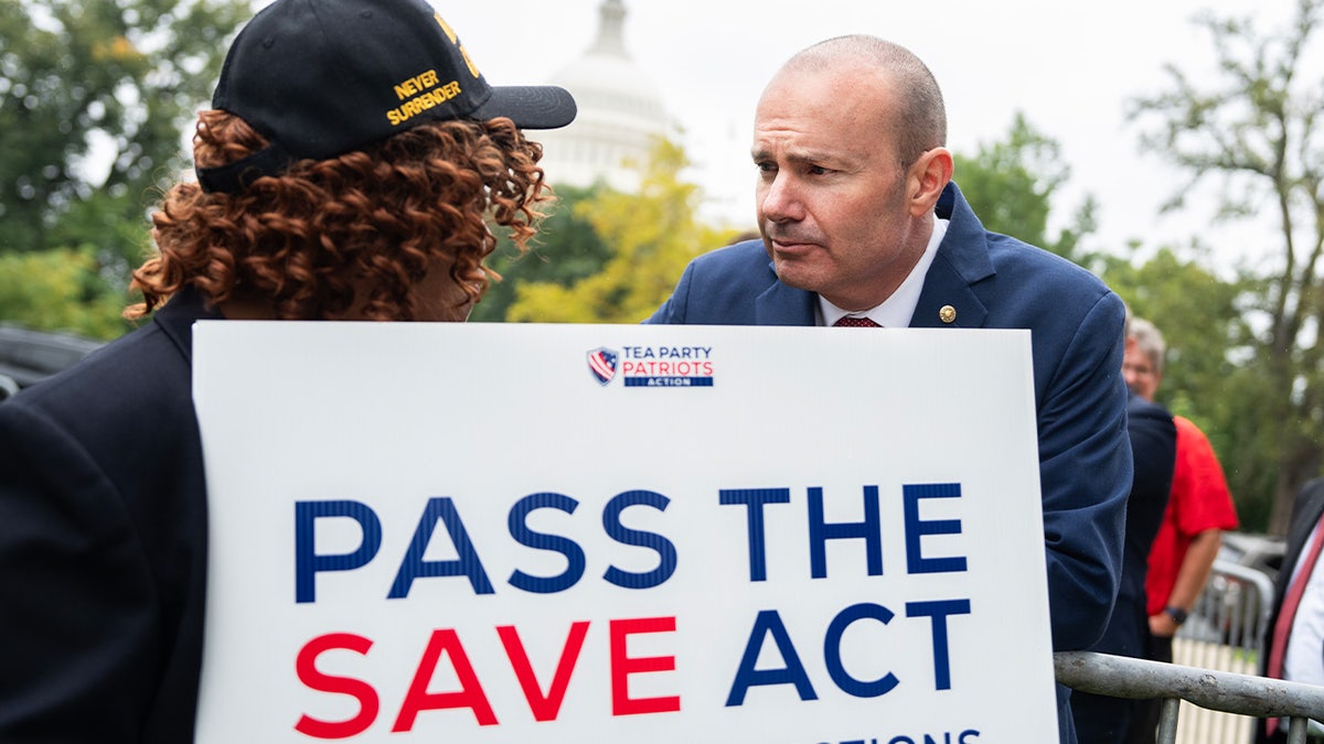 Mike Lee with a "Pass the SAVE Act" sign