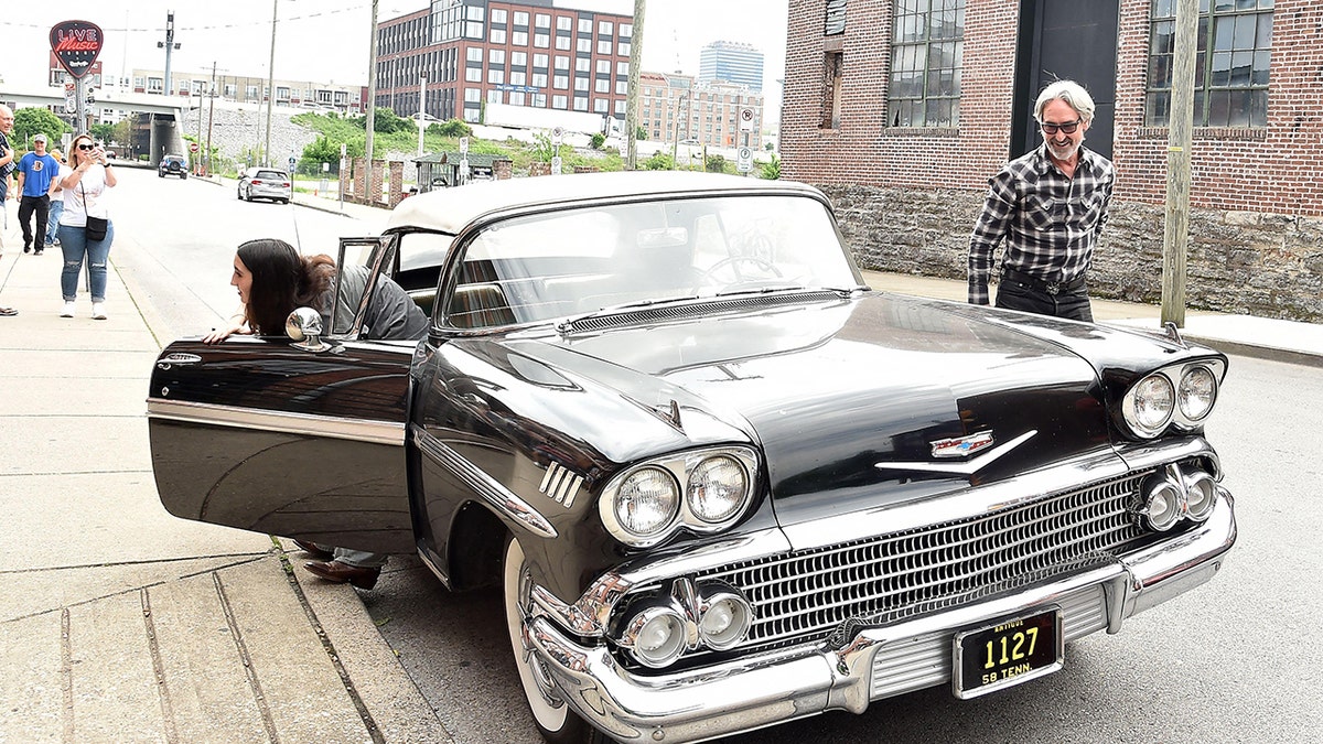 Mike Wolfe admiring a car.