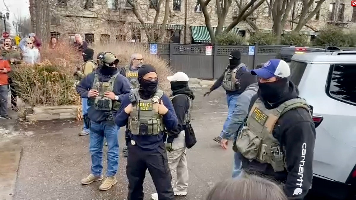 ICE agents standing.