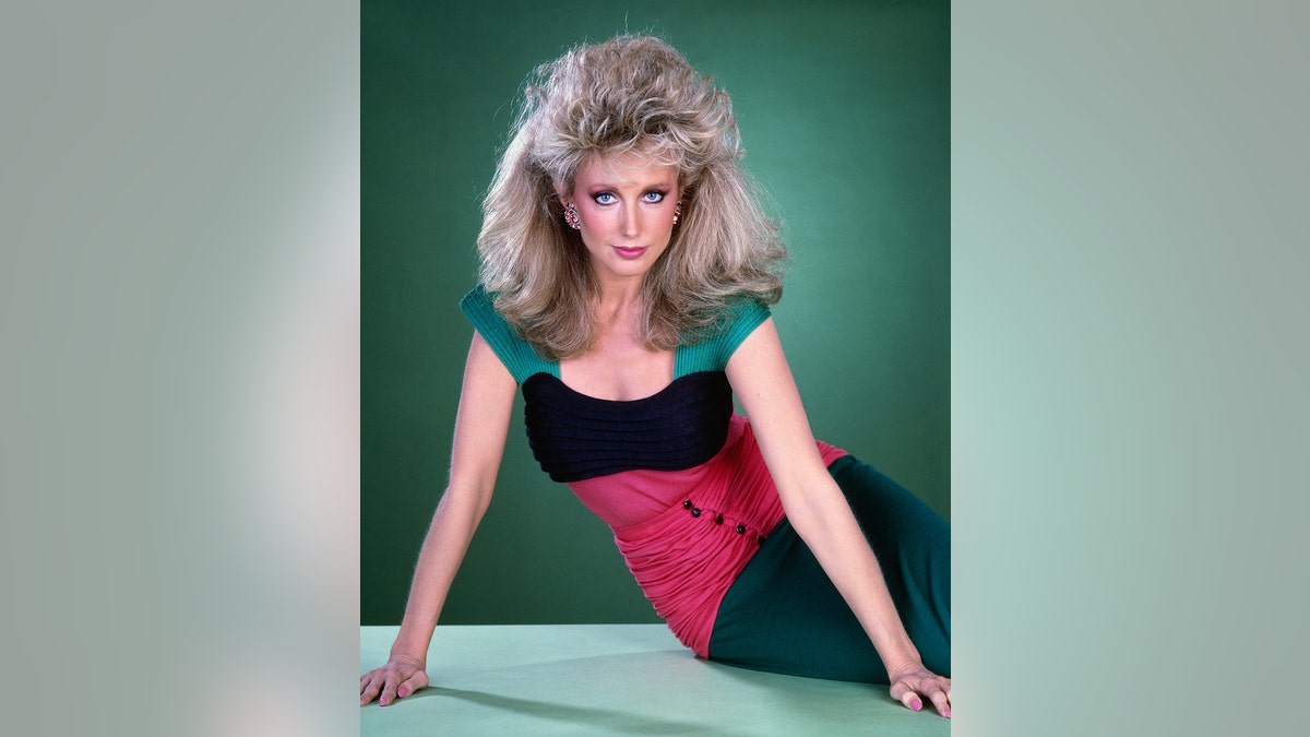 Morgan Fairchild in abiti anni '80 e capelli voluminosi per "Cresta del falco."
