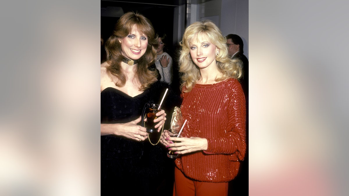 Morgan Fairchild vestita tutta di rosso con sua sorella tutta vestita di nero negli anni '80.