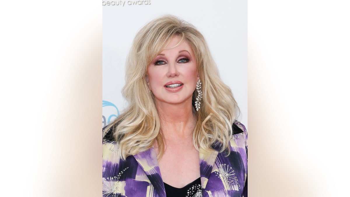 Un primo piano di Morgan Fairchild che indossa un blazer viola.