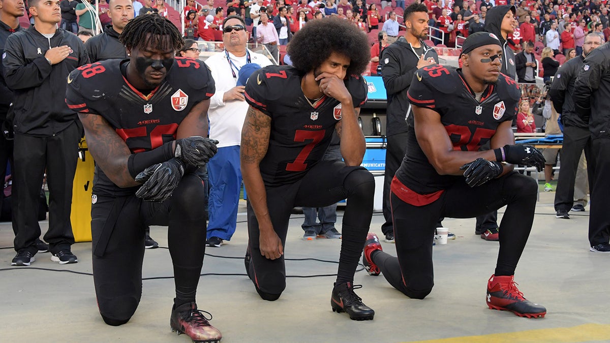 Colin Kaepernick kneels with his teammates