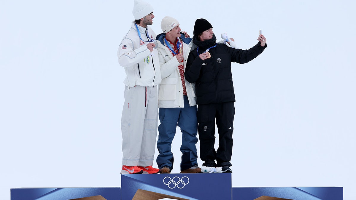 Alex Hall takes a photo with his fellow medalists