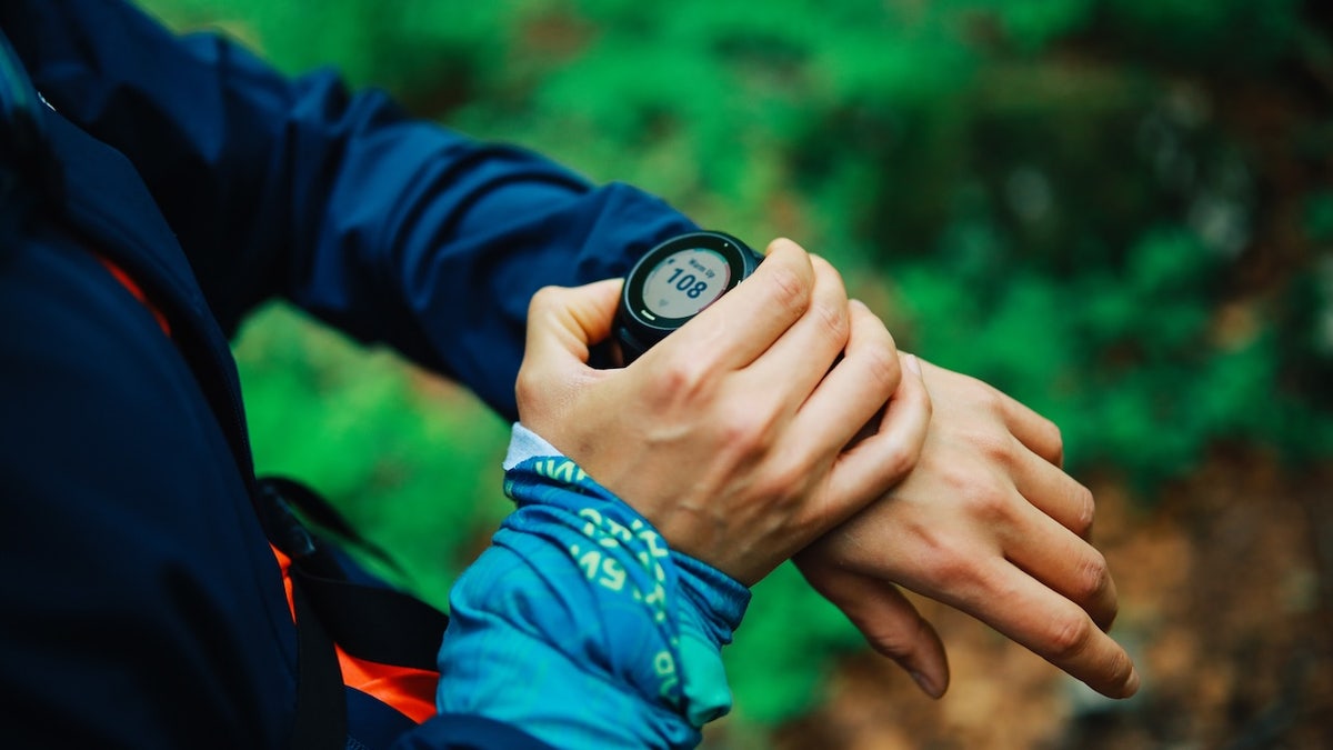 runner checking smart watch in the forest
