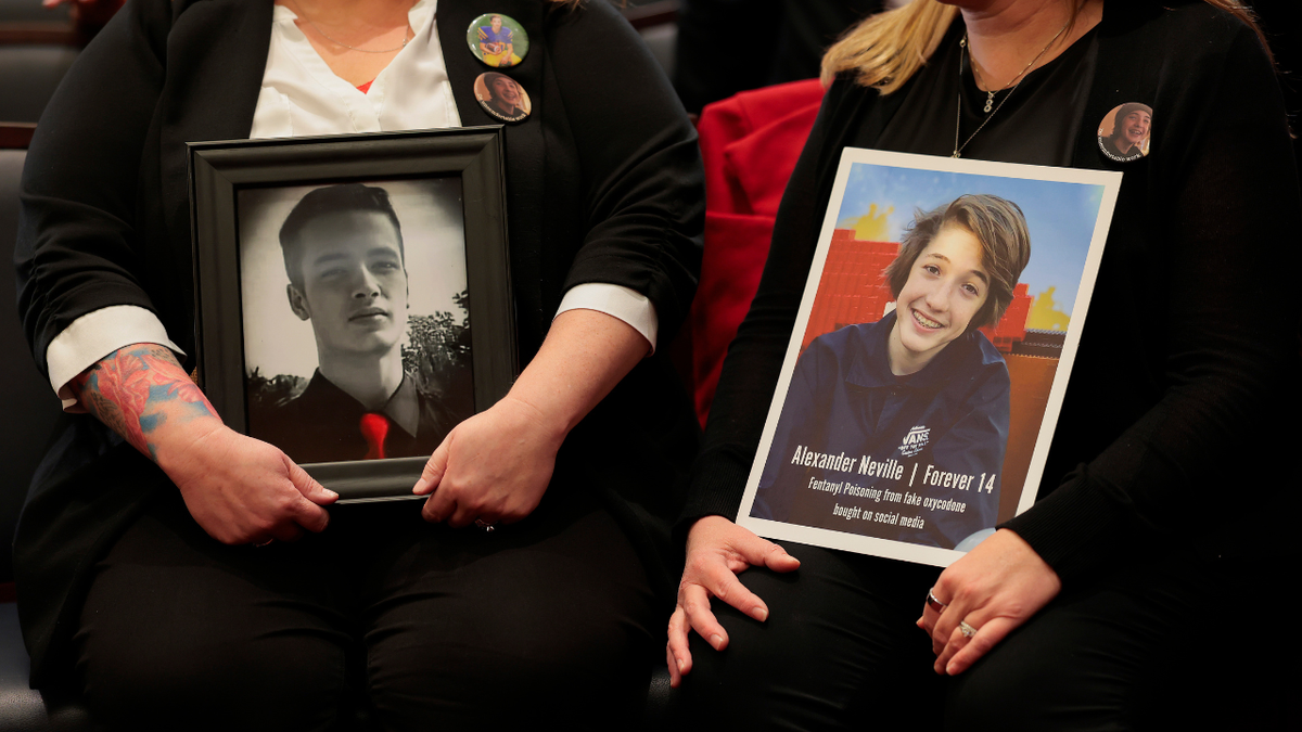Mothers hold photographs of their sons who passed away from social media abuse during a press conference on Capitol Hill.