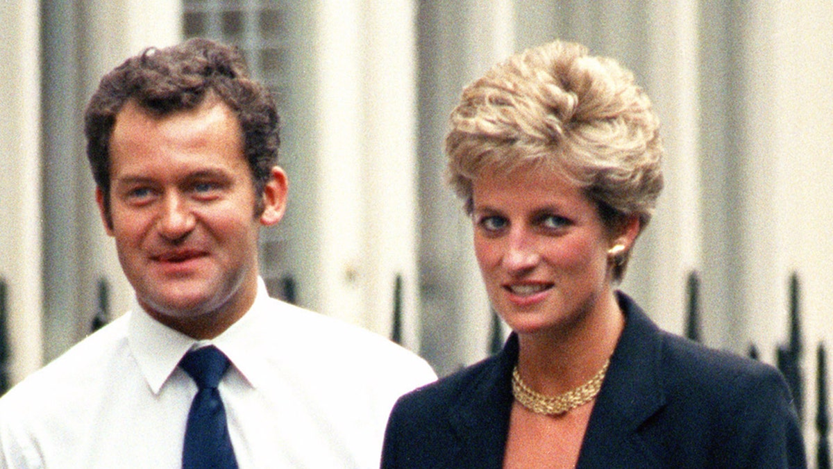 Paul Burrell in a white shirt and blue tie walking next to Princess Diana in a dark blue blazer.