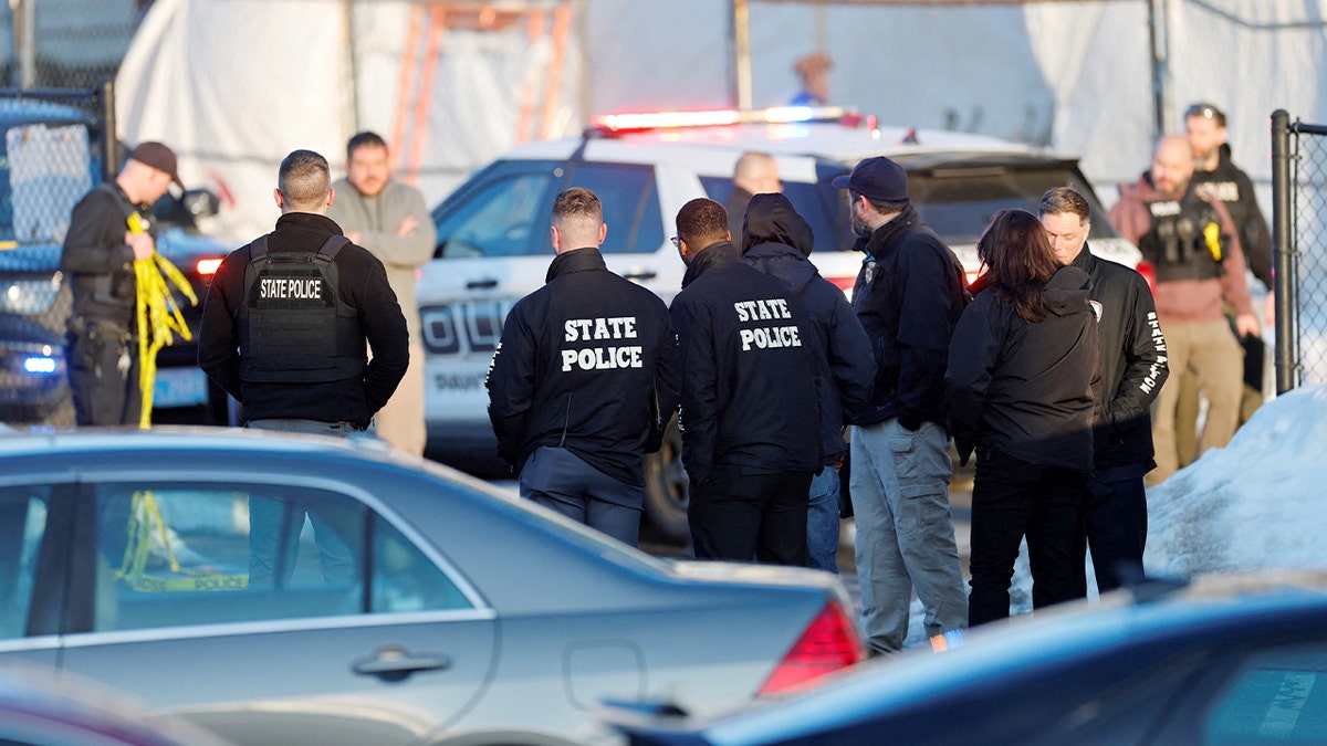 Law enforcement officers gathered near the entrance of an indoor ice rink following a reported incident.