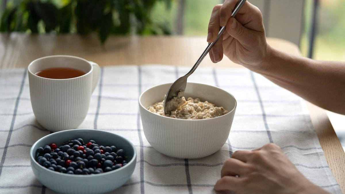 Woman at table eating oatmeal
